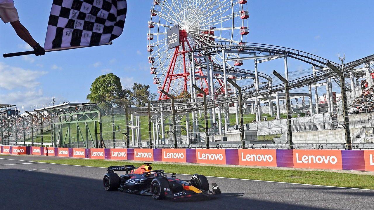 Red Bull Racing's Dutch driver Max Verstappen is greeted by the checkered flag as he wins the Formula One Japanese Grand Prix.
